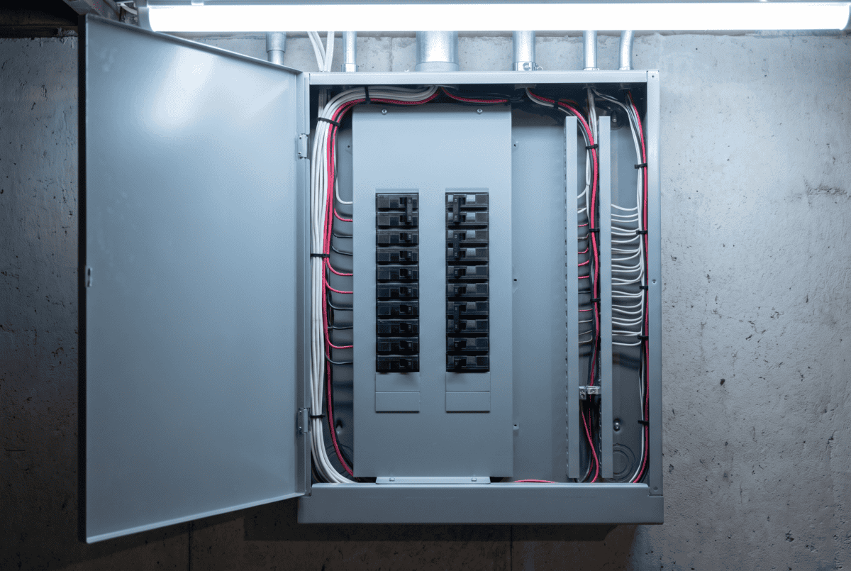 Open American residential electrical breaker panel showing two columns of black toggle circuit breakers in a grey steel enclosure